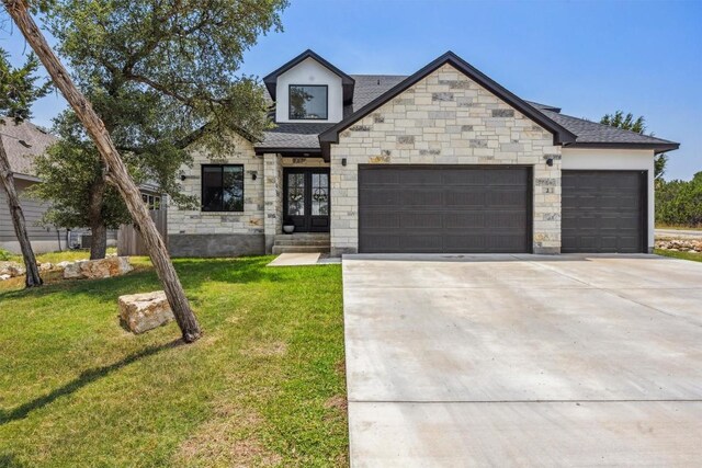 2 Basswood Cir, Wimberley, TX 78676 - view of front of home featuring an attached garage, stone siding, driveway, a front lawn, and french doors