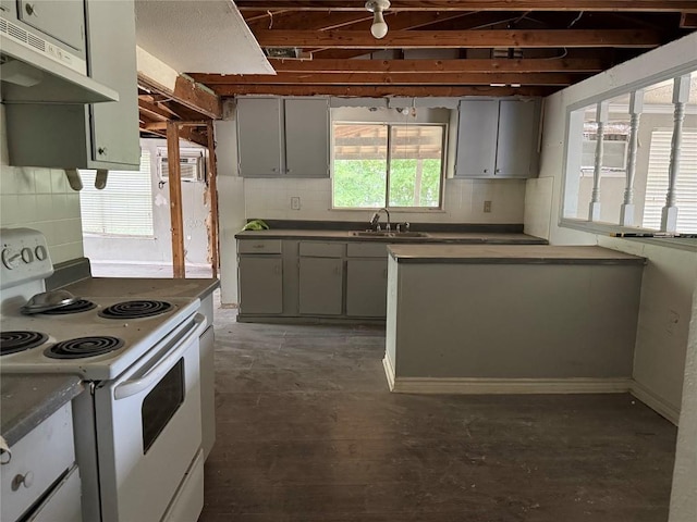 2505 Gardenia Dr, Austin, TX 78727 - kitchen with white electric stove, gray cabinetry, under cabinet range hood, a sink, and dark countertops