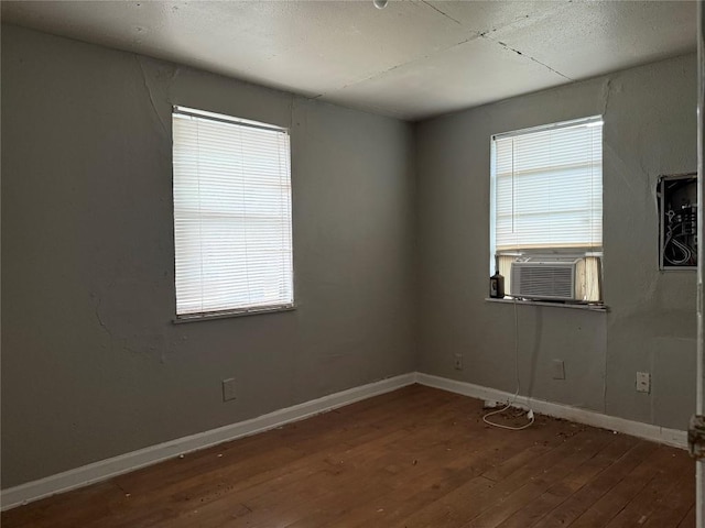 2505 Gardenia Dr, Austin, TX 78727 - empty room featuring cooling unit, hardwood / wood-style flooring, healthy amount of natural light, and baseboards