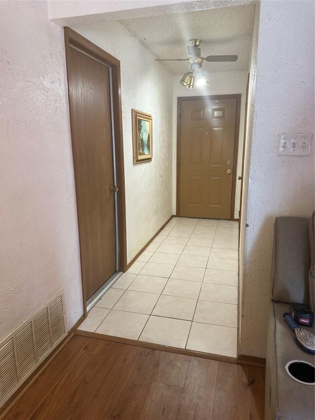 6400 Earlyway Dr, Austin, TX 78749 - hallway featuring a textured wall, light wood finished floors, and baseboards
