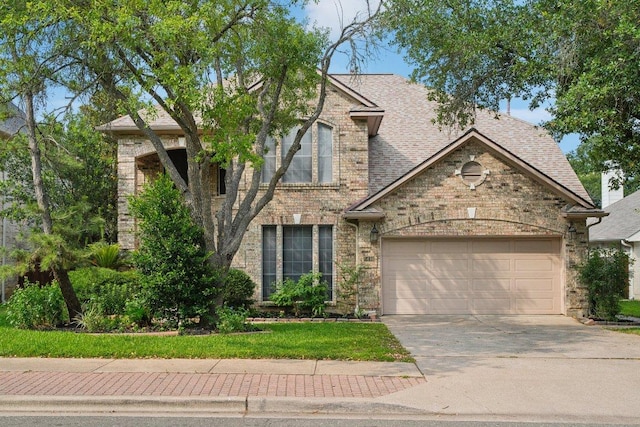 5616 Gorham Glen Ln, Austin, TX 78739 - view of front of house featuring an attached garage, driveway, brick siding, and a shingled roof