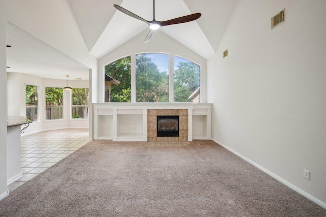 5616 Gorham Glen Ln, Austin, TX 78739 - unfurnished living room featuring ceiling fan, healthy amount of natural light, a tiled fireplace, carpet, and vaulted ceiling