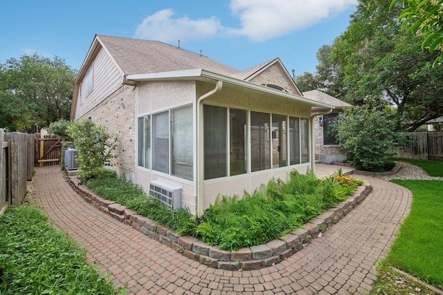 5616 Gorham Glen Ln, Austin, TX 78739 - view of side of property with a fenced backyard, a sunroom, central AC, and brick siding