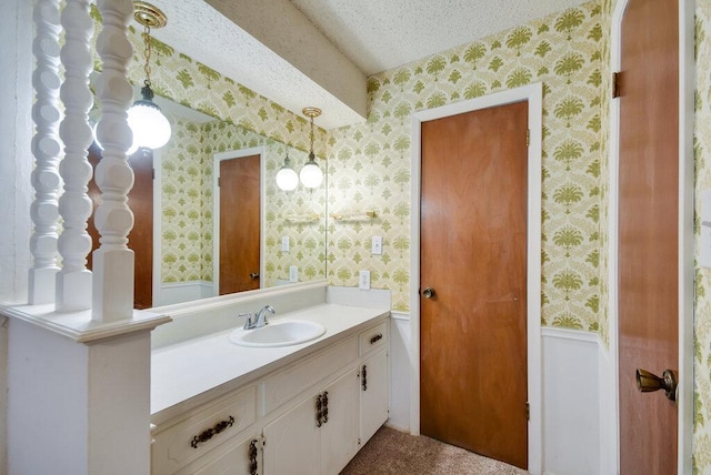 301 Navajo Trl, Georgetown, TX 78633 - bathroom featuring wallpapered walls, vanity, and a textured ceiling