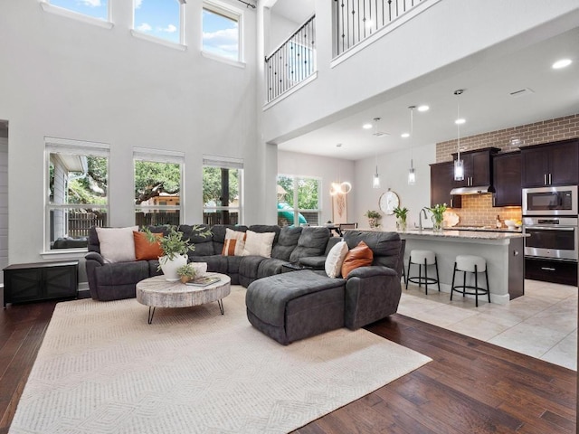 116 Claiborne Lake Ln, Georgetown, TX 78628 - living room featuring light wood finished floors, a towering ceiling, and recessed lighting