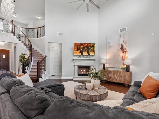 116 Claiborne Lake Ln, Georgetown, TX 78628 - living area with a high ceiling, wood finished floors, a ceiling fan, stairway, and a warm lit fireplace