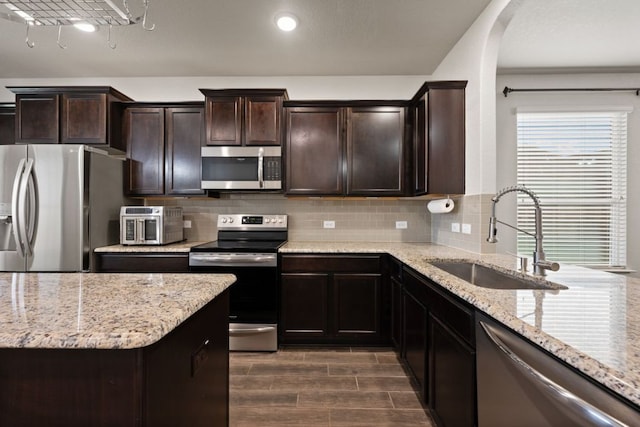 854 Pumpkin Rdg, New Braunfels, TX 78130 - kitchen featuring appliances with stainless steel finishes, a sink, backsplash, light stone counters, and recessed lighting