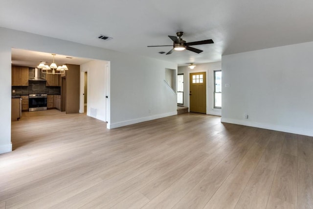 7702 Turquoise Trl, Austin, TX 78749 - unfurnished living room with a chandelier, light wood-style floors, a ceiling fan, and baseboards