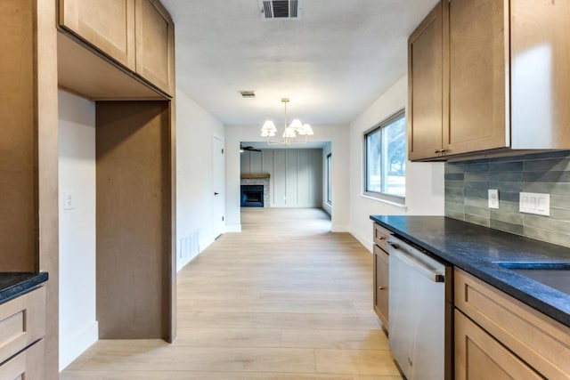 7702 Turquoise Trl, Austin, TX 78749 - kitchen featuring dishwashing machine, dark countertops, backsplash, and light wood-style floors