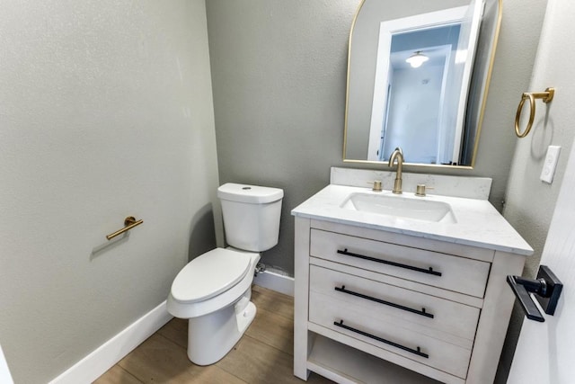 7702 Turquoise Trl, Austin, TX 78749 - bathroom featuring toilet, vanity, wood finished floors, and baseboards
