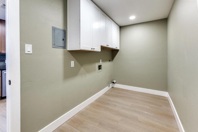 7702 Turquoise Trl, Austin, TX 78749 - laundry room featuring cabinet space, washer hookup, electric panel, light wood-style floors, and baseboards