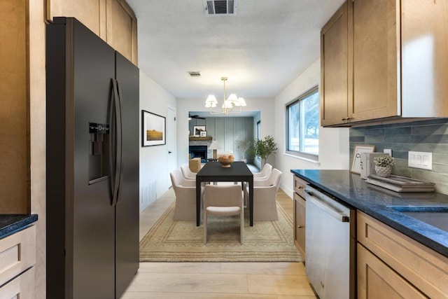 7702 Turquoise Trl, Austin, TX 78749 - kitchen with dishwasher, black fridge with ice dispenser, a chandelier, light wood-style flooring, and tasteful backsplash