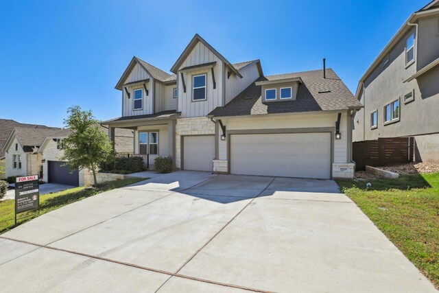 16825 Roselin Dr, Austin, TX 78738 - view of front of home featuring board and batten siding, stone siding, concrete driveway, roof with shingles, and an attached garage