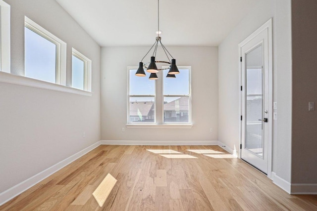 16825 Roselin Dr, Austin, TX 78738 - unfurnished dining area with a chandelier, light wood-style floors, and baseboards