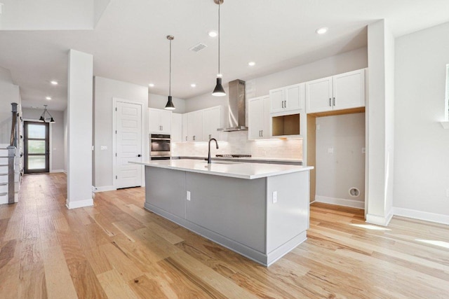16825 Roselin Dr, Austin, TX 78738 - kitchen featuring wall chimney exhaust hood, a kitchen island with sink, decorative backsplash, white cabinetry, and recessed lighting