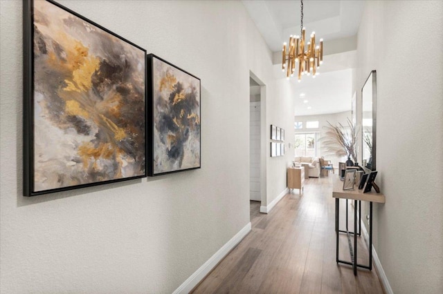 1504 Saddlespur Ln, Leander, TX 78641 - hall with baseboards, wood finished floors, a chandelier, and a tray ceiling