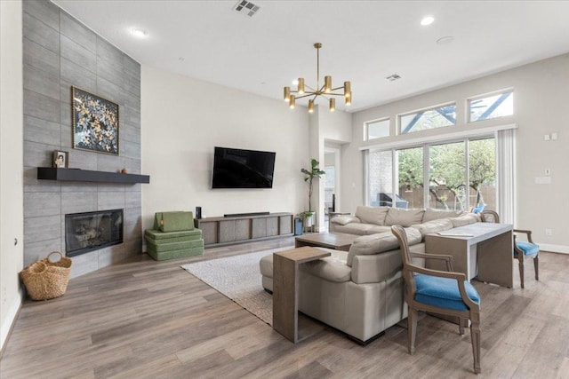 1504 Saddlespur Ln, Leander, TX 78641 - living room featuring a fireplace, light wood-style flooring, a chandelier, recessed lighting, and baseboards