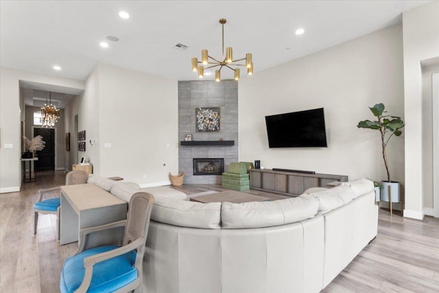1504 Saddlespur Ln, Leander, TX 78641 - living area with a chandelier, light wood-type flooring, recessed lighting, baseboards, and a tile fireplace