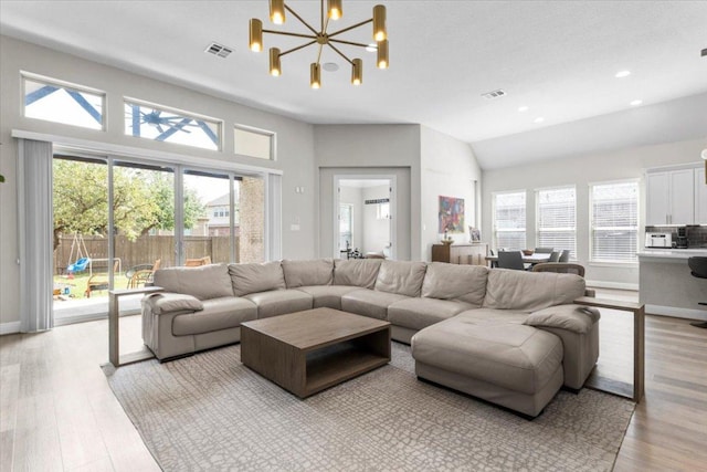 1504 Saddlespur Ln, Leander, TX 78641 - living room with healthy amount of natural light, light wood-style floors, vaulted ceiling, a chandelier, and recessed lighting