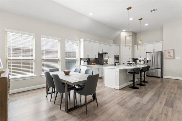 1504 Saddlespur Ln, Leander, TX 78641 - dining space featuring wood finished floors, recessed lighting, and lofted ceiling