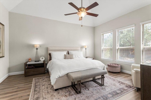 1504 Saddlespur Ln, Leander, TX 78641 - bedroom featuring multiple windows, wood finished floors, vaulted ceiling, and a ceiling fan