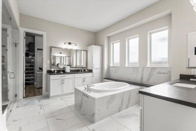 1504 Saddlespur Ln, Leander, TX 78641 - full bath with marble finish floors, vanity, a bath, a shower stall, and a spacious closet