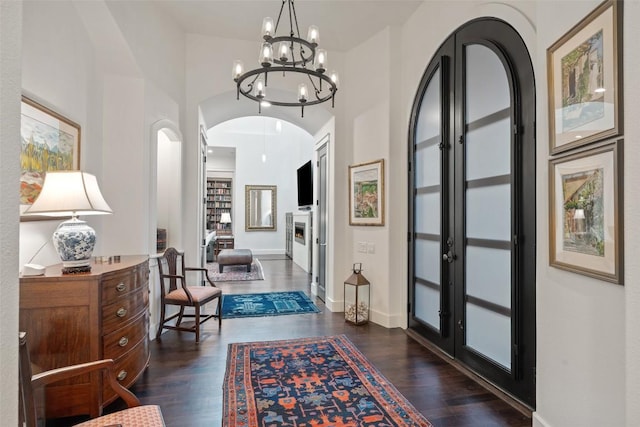 104 Sendera Bonita, Lakeway, TX 78734 - foyer entrance with arched walkways, dark wood-type flooring, a chandelier, and french doors