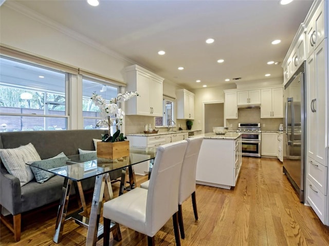 203 Wallis Dr, Austin, TX 78746 - dining area with crown molding, healthy amount of natural light, recessed lighting, and light wood-style flooring