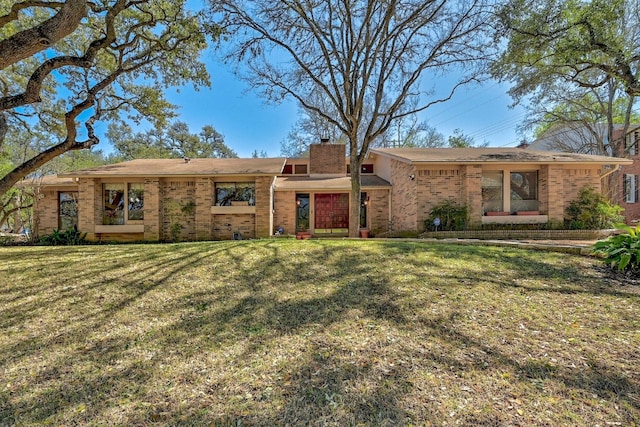 2804 Rock Way, Austin, TX 78746 - view of front facade with a chimney, brick siding, and a front yard