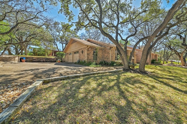 2804 Rock Way, Austin, TX 78746 - view of property exterior with brick siding, driveway, an attached garage, and a lawn