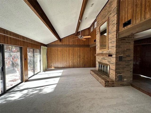 2804 Rock Way, Austin, TX 78746 - unfurnished living room with wooden walls, a textured ceiling, carpet flooring, ceiling fan, and a brick fireplace