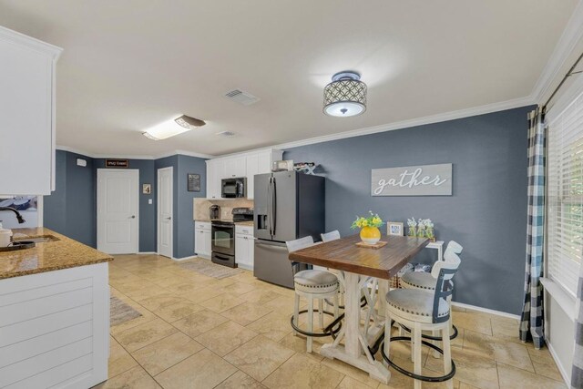 116 Bufflehead, Leander, TX 78641 - kitchen with black appliances, white cabinetry, crown molding, a sink, and light stone countertops