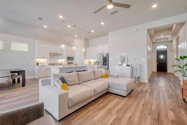 108 Windgate Dr, Hutto, TX 78634 - living area with light wood finished floors, a ceiling fan, baseboards, recessed lighting, and a high ceiling