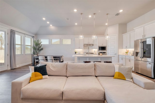 108 Windgate Dr, Hutto, TX 78634 - living area featuring lofted ceiling, wood finished floors, and recessed lighting
