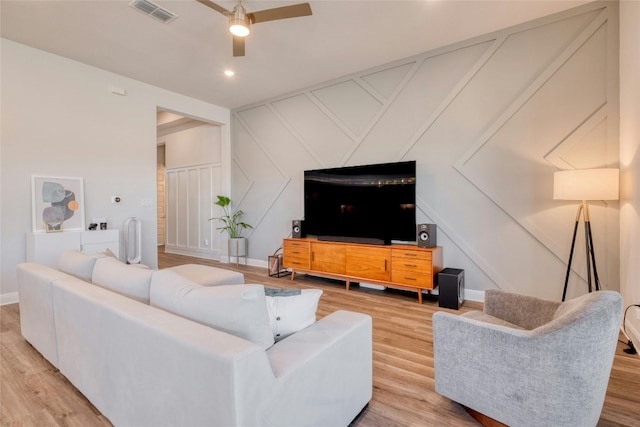 108 Windgate Dr, Hutto, TX 78634 - living area featuring light wood-type flooring, a ceiling fan, a decorative wall, and baseboards