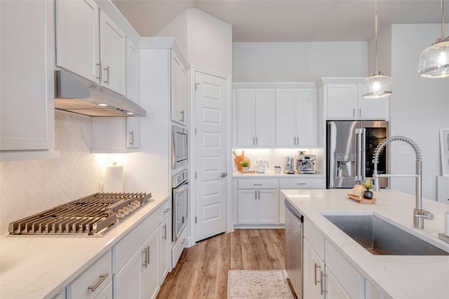108 Windgate Dr, Hutto, TX 78634 - kitchen with a sink, stainless steel appliances, under cabinet range hood, white cabinetry, and backsplash