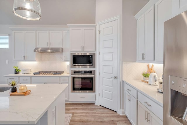 108 Windgate Dr, Hutto, TX 78634 - kitchen with appliances with stainless steel finishes, white cabinetry, tasteful backsplash, and light wood-type flooring
