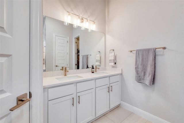 108 Windgate Dr, Hutto, TX 78634 - bathroom with double vanity, a walk in closet, tile patterned flooring, and baseboards