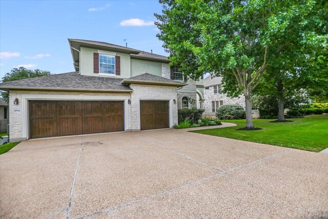 10524 Roy Butler Dr, Austin, TX 78717 - view of front of home with driveway, a front yard, stucco siding, an attached garage, and a shingled roof