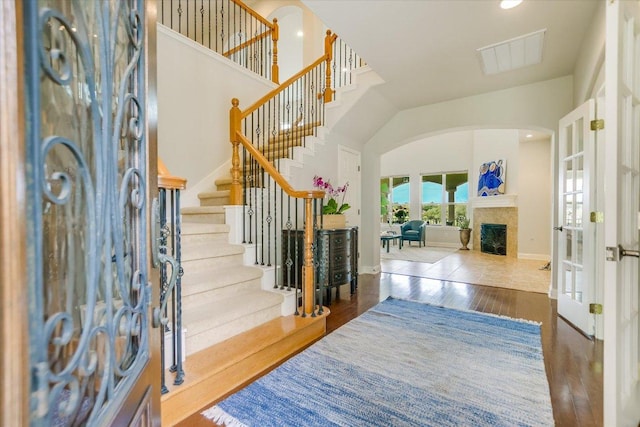 10524 Roy Butler Dr, Austin, TX 78717 - foyer with arched walkways, wood finished floors, a high ceiling, stairway, and a fireplace