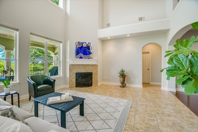 10524 Roy Butler Dr, Austin, TX 78717 - tiled living area featuring a high ceiling, a tile fireplace, arched walkways, and baseboards