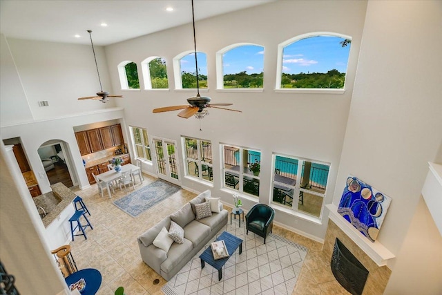 10524 Roy Butler Dr, Austin, TX 78717 - living area with a ceiling fan, a fireplace, a high ceiling, light tile patterned floors, and recessed lighting