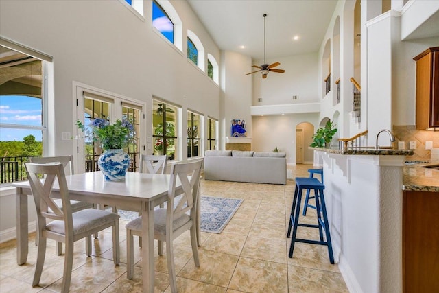 10524 Roy Butler Dr, Austin, TX 78717 - dining space with ceiling fan, healthy amount of natural light, a high ceiling, arched walkways, and light tile patterned floors