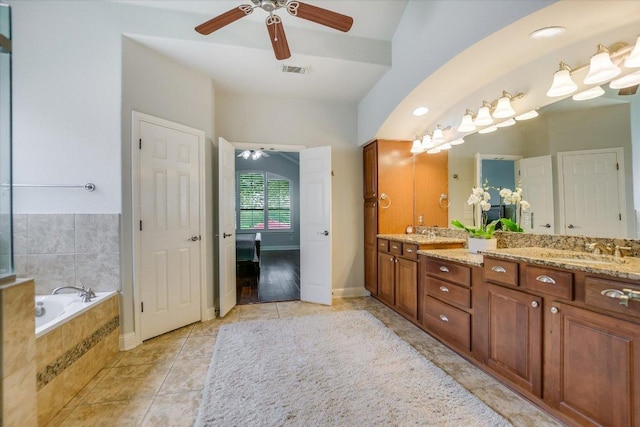 10524 Roy Butler Dr, Austin, TX 78717 - bathroom with double vanity, ceiling fan, a garden tub, baseboards, and tile patterned flooring