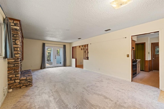 1012 Chesapeake Dr, Austin, TX 78758 - unfurnished living room with a textured ceiling, carpet floors, and french doors