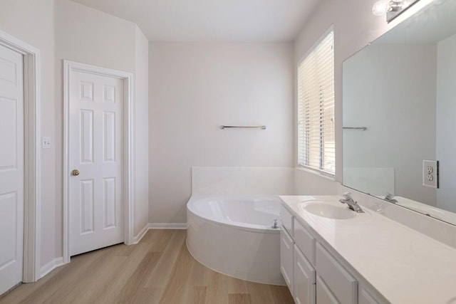 14943 Doria Dr, Austin, TX 78728 - full bathroom featuring wood finished floors, a bath, vanity, and baseboards