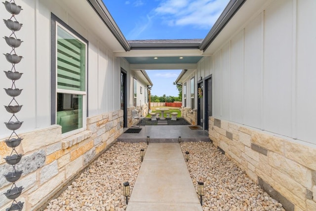 123 Zacate St, Elgin, TX 78621 - view of property exterior with stone siding, board and batten siding, and a patio
