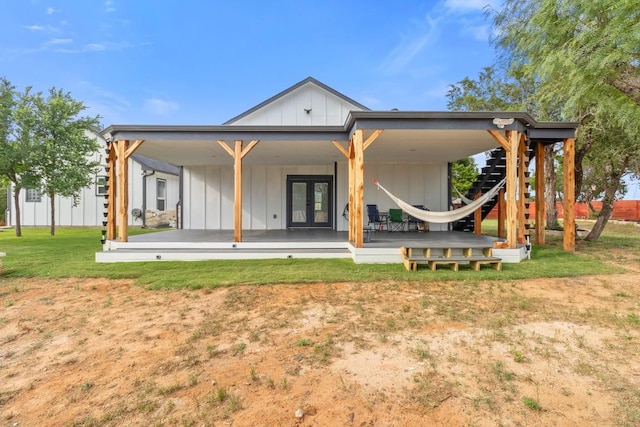 123 Zacate St, Elgin, TX 78621 - back of property featuring board and batten siding, french doors, a yard, and a deck