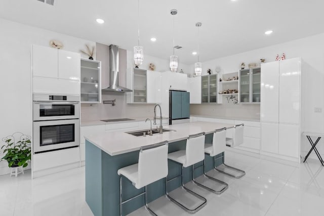 123 Zacate St, Elgin, TX 78621 - kitchen featuring freestanding refrigerator, wall chimney exhaust hood, white double oven, white cabinets, and light countertops
