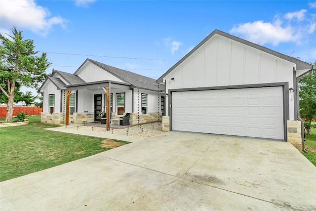 123 Zacate St, Elgin, TX 78621 - modern farmhouse style home with board and batten siding, a porch, a front yard, roof with shingles, and concrete driveway